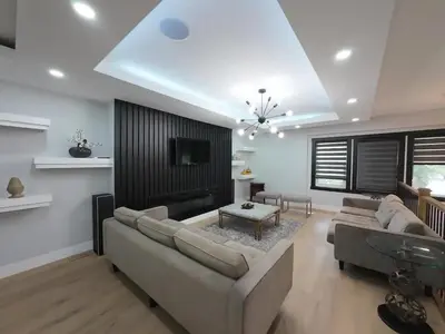 a living room with a large couch and a tv at The Luxe Escape Calgary I 3BR Vacation Home in Calgary