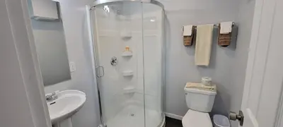 a bathroom with a shower and a toilet and a sink at Riverside Court RV and Cabins in Grand Forks