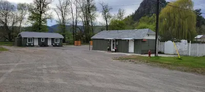 a couple of small buildings next to a dirt road at Riverside Court RV and Cabins in Grand Forks