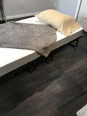 a bed in a room with a wooden floor at Riverside Court RV and Cabins in Grand Forks
