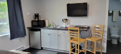 a kitchen with a sink and a counter with a table and chairs at Riverside Court RV and Cabins in Grand Forks