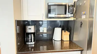 a kitchen counter with a coffee maker and a microwave at The Ridge Escape-3BR Deluxe Stay in Calgary