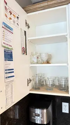 a kitchen pantry with bowls and a microwave at The Ridge Escape-3BR Deluxe Stay in Calgary