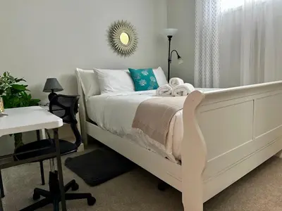 a bedroom with a bed and a desk and a mirror at Global Family Canada in Calgary
