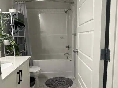a white bathroom with a shower and a toilet at Global Family Canada in Calgary