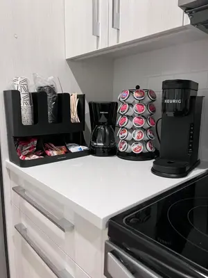 a kitchen counter with a coffee maker and cupcakes at Cozy home away from home in Calgary
