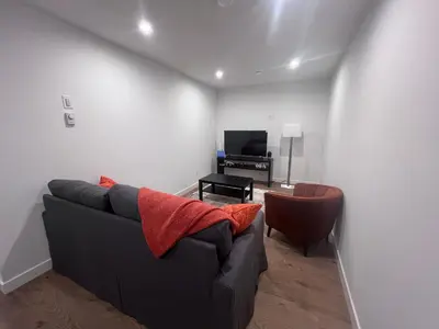 a living room with a couch and a television at Cozy home away from home in Calgary