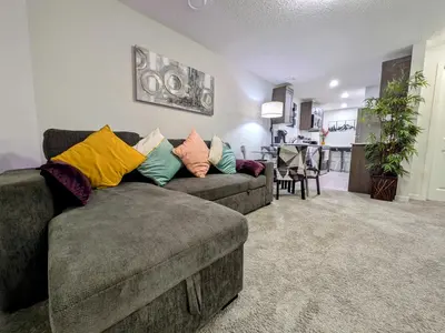 a living room with a couch with colorful pillows at Glacier Ridge 1 bedroom haven in Calgary