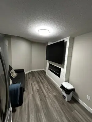 a living room with a flat screen tv on a wall at Entire 2 Ensuite Bedrooms in a Basement in Edmonton