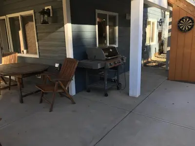 a patio with a grill and a table and chairs at Simcoe B&B - Incredible vacation suite in Smithers