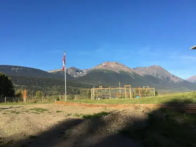 a field with a flag and mountains in the background at Simcoe B&B - Incredible vacation suite in Smithers