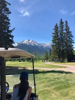 a woman sitting in a golf cart looking at the mountains at Simcoe B&B - Incredible vacation suite in Smithers