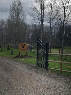 a gate at a park with a sign and a fence at Simcoe B&B - Incredible vacation suite in Smithers