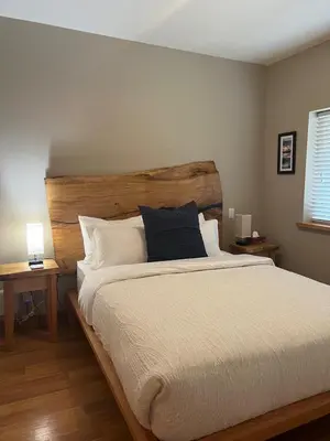 a bedroom with a large bed with a wooden headboard at The Moorage - Luxury 2 bed & 2 bath Condo on Marina in Ucluelet
