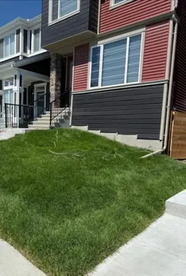 a house with a green lawn in front of it at Relax, Recharge, Repeat 2Bedroom Walkout Haven in Calgary