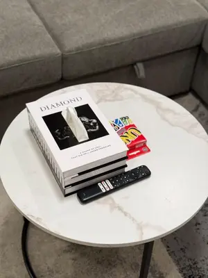 a book and a remote control on a table at Relax, Recharge, Repeat 2Bedroom Walkout Haven in Calgary
