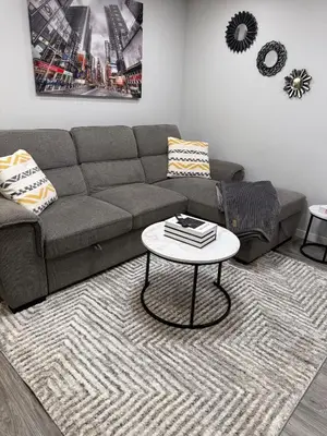 a living room with a couch and a table at Relax, Recharge, Repeat 2Bedroom Walkout Haven in Calgary