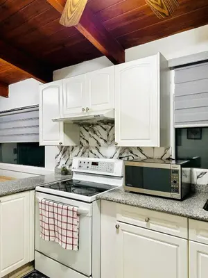 a kitchen with white cabinets and a stove top oven at P&N Suites - Queen Room- DUBAI in Edmonton