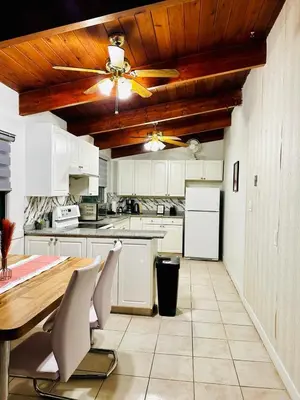 a kitchen with white cabinets and a ceiling fan at P&N Suites - DELUXE QUEEN ROOM- LONDON in Edmonton