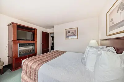 a hotel room with a bed and a tv at Grande Cache Inn & Suites in Grande Cache