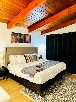 a bedroom with a large bed with black curtains at P&N Suites - DELUXE KING ROOM- PARIS in Edmonton