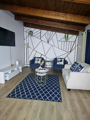 a living room with a couch and a table at P&N Suites - DELUXE KING ROOM- PARIS in Edmonton
