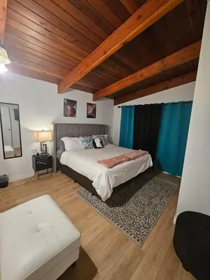 a bedroom with a large bed and a wooden ceiling at P&N Suites - DELUXE KING ROOM- PARIS in Edmonton
