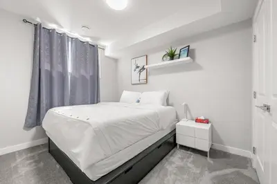 a white bedroom with a large bed and a window at Entire 1 bed and Den Near YEG International Airport in Nisku