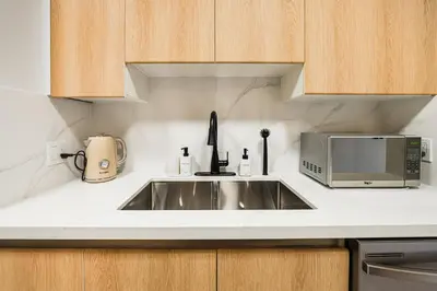 a kitchen with a sink and a microwave at Modern & Cozy Home in the Heart of Downtown Vancouver in Vancouver