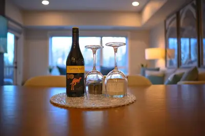 a bottle of wine and two glasses on a table at 2 bedrooms-3 beds 2 baths-Rocky Creekside Retreat - Top Floor - Heated Pool and Hot Tub in Dead Man's Flats