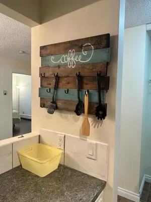a kitchen with a wooden wall with utensils on it at Cozy & bright private one-bed rm in Edmonton