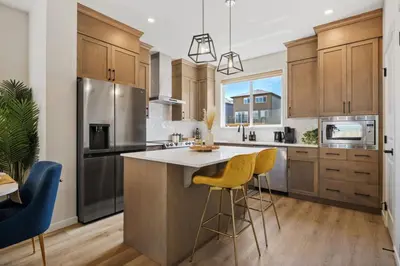 a kitchen with stainless steel appliances and wooden cabinets at 3 Bedroom Detached Home with Free Parking, Netflix, Free Banff Pass, King Size Bed & Portable AC in Balzac