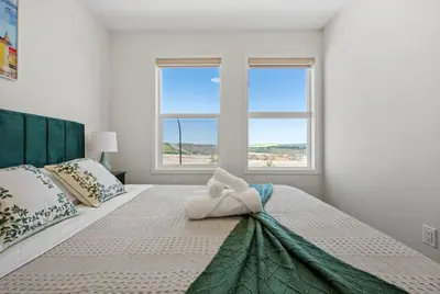 a bedroom with a bed with a towel on it at 3 Bedroom Detached Home with Free Parking, Netflix, Free Banff Pass, King Size Bed & Portable AC in Balzac