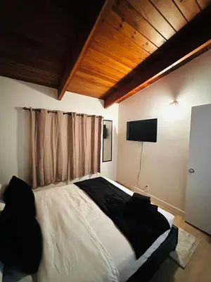 a bedroom with a large bed with a television on the wall at P and N Suites in Edmonton