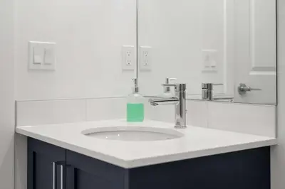 a bathroom sink with a bottle of soap on it at Skyline Retreat Spacious 4BR Home with Balcony! in Calgary