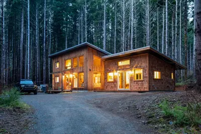a log cabin in the middle of a forest at Jordan River Coastal Cottage in Shirley