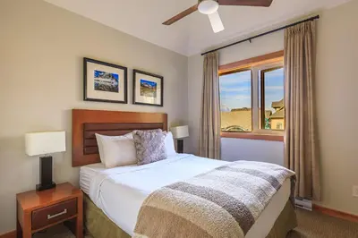 a bedroom with a large bed and a window at Alpine at The Lodges of Canmore in Canmore