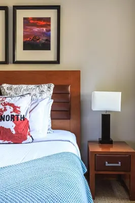 a bedroom with a bed and a table with a lamp at Alpine at The Lodges of Canmore in Canmore