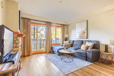 a living room with a couch and a tv at Alpine at The Lodges of Canmore in Canmore