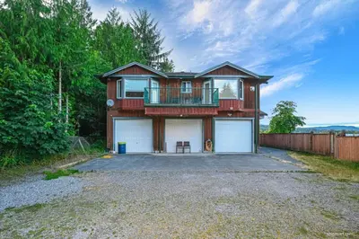 a house with a balcony on top of a driveway at Fort Wine Burrow, Entire Private Estate Home in Maple Ridge District Municipality