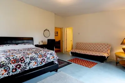 a bedroom with a bed and a couch and a table at Fort Wine Manor, Entire Private Estate Home in Maple Ridge District Municipality
