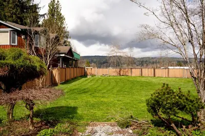 a yard with a fence and a house at Fort Wine Manor, Entire Private Estate Home in Maple Ridge District Municipality