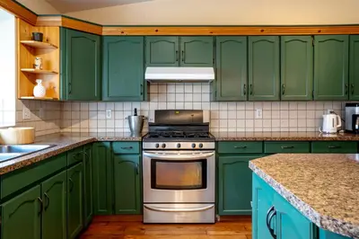 a green kitchen with green cabinets and a stove at Fort Wine Manor, Entire Private Estate Home in Maple Ridge District Municipality