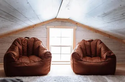 two brown leather chairs sitting in a attic at Quiet Country Cabin in Waiparous Village