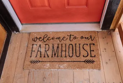 a welcome to our farmhouse sign in front of a door at Quiet Country Cabin in Waiparous Village