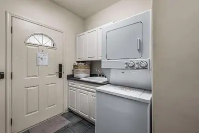 a kitchen with white cabinets and a white door at The Marmot's Den in Sun Peaks