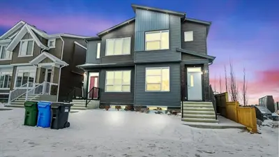 a house in the snow with two trash cans in front of it at A Home away from Home in Calgary
