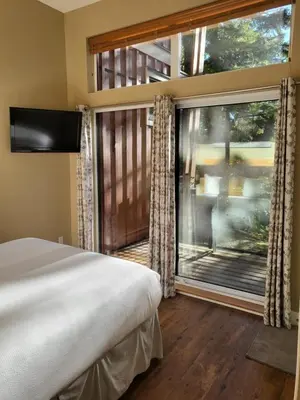 a bedroom with a bed and a large window at Surfers' Nest - Waterfront home in Ucluelet in Ucluelet