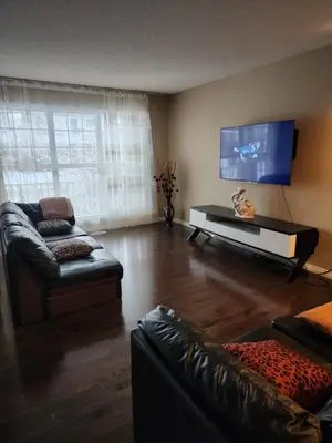 a living room with a couch and a flat screen tv at Cozy Luxury House in Edmonton