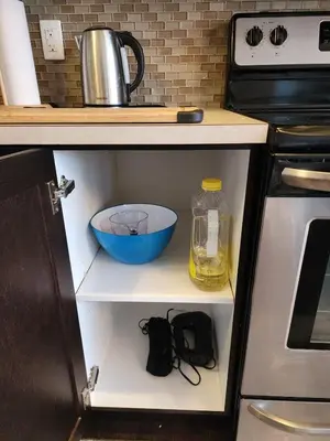 a cupboard with a bowl and a bottle of oil on it at Cozy Luxury House in Edmonton